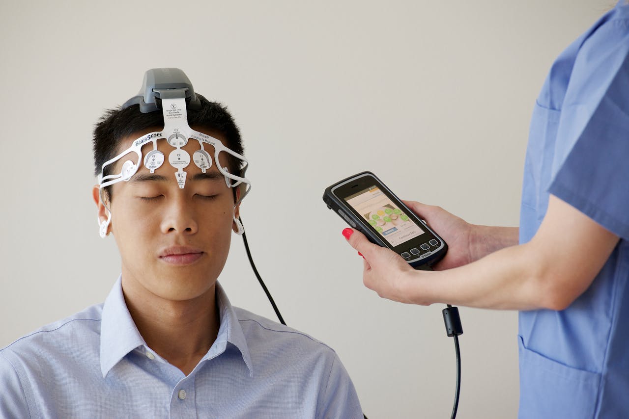 services-img Healthcare professional conducting an EEG examination using a Brainscope device on a male patient.
